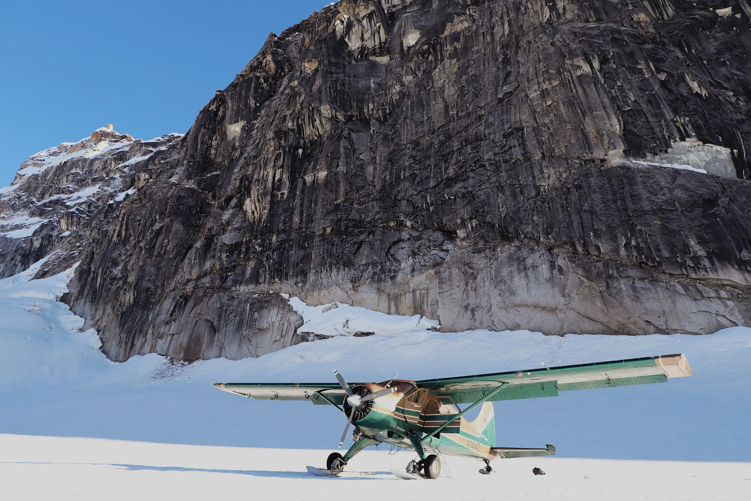 Light aircraft on a remote snow strip below mountains
